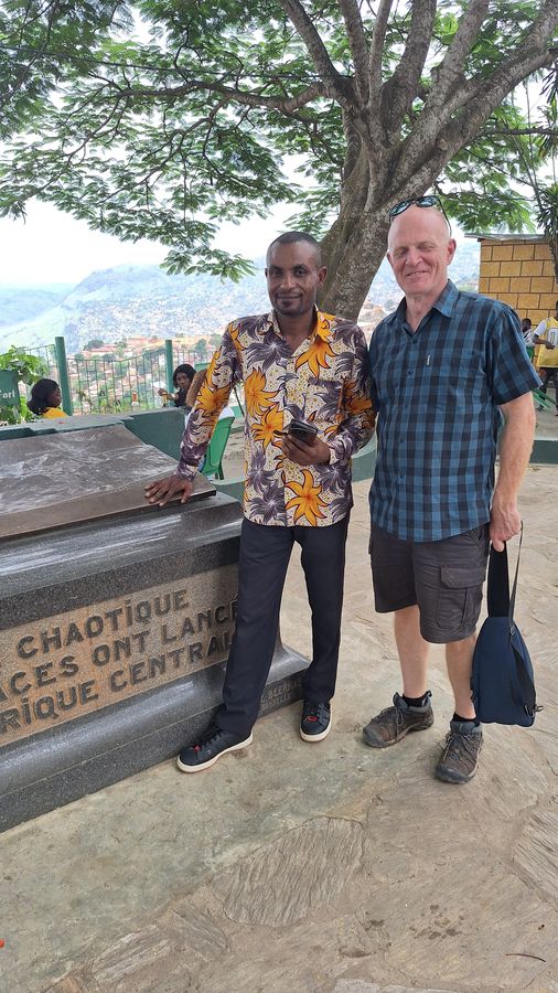 Martin et un ami devant un monument en Afrique centrale